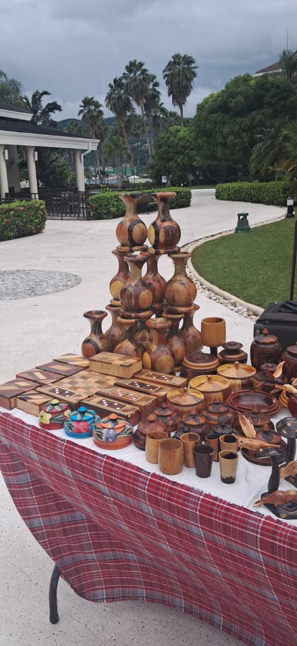 Tall turned-wood vases and decorative pieces displayed on a market table at a Jamaican resort