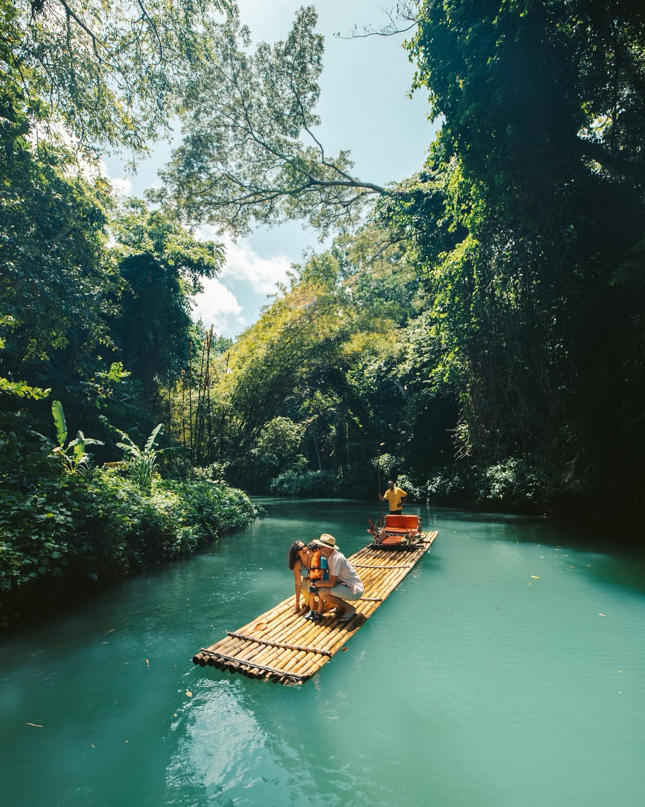 Family bamboo rafting down the Martha Brae river through the rainforest