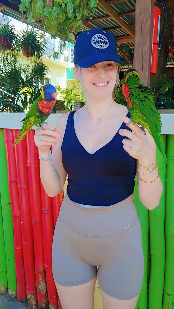 Traveller holding colourful parrots at a tropical Jamaican stop